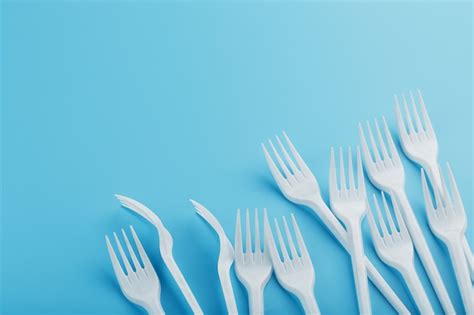 Premium Photo White Plastic Forks Of Disposable Tableware On A Blue Wall