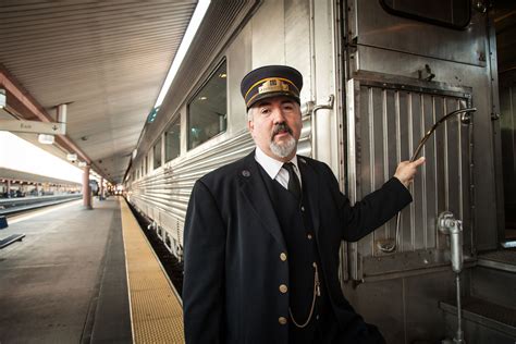 Train Conductor Standing Next To Passenger Train On Train Station