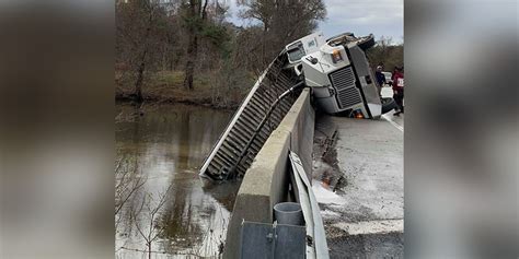 Driver Charged After Dump Truck Crashes Hangs Off Bridge