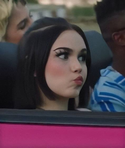 a woman with black hair sitting in a car