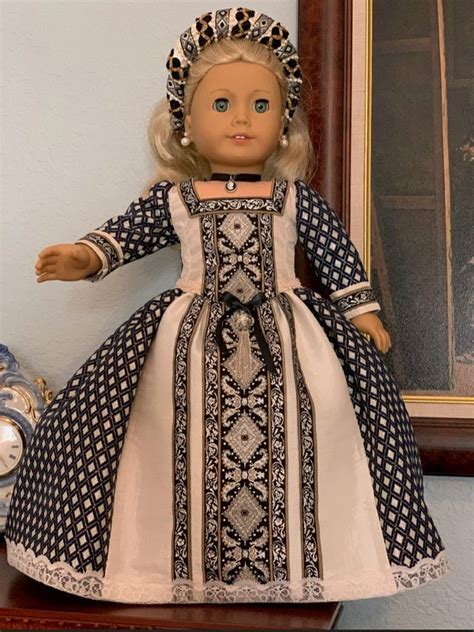 a doll with blonde hair wearing a blue and white dress sitting on a shelf next to a clock