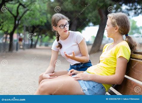 Two Girls Sitting On Bench In Park And Laughing Stock Image Image Of Communication Young