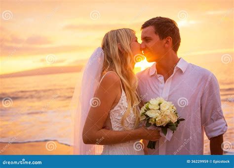 Just Married Couple Kissing on Tropical Beach at Sunset Stock Image