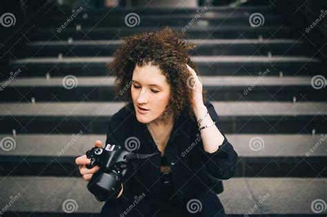 Cool Brunette Girl Holding Camera Sitting On Stair Inside The Building