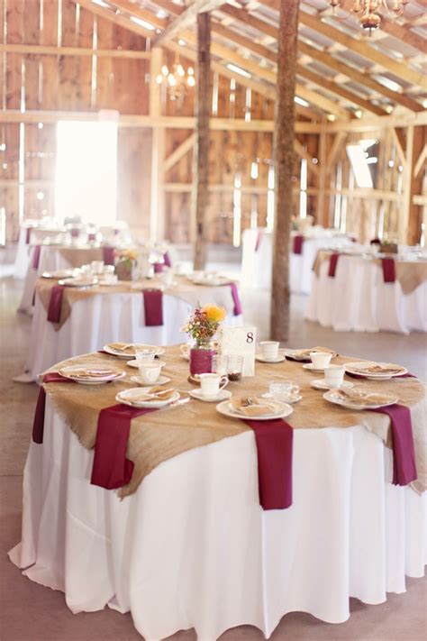 Decorated area in gold and burgundy colors with white candles and flowers. Burgundy Wedding Theme | Wedding Ideas By Colour | CHWV