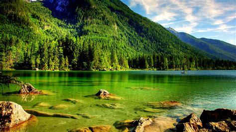 Body Of Water Beside Green Trees Covered Mountain Under Blue White