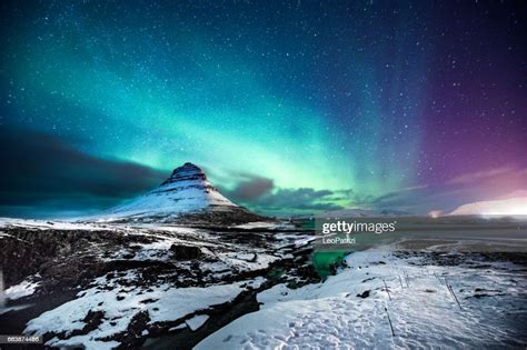 Northern Lights In Mount Kirkjufell Iceland With A Man Passing By High