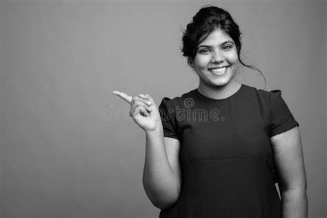 Young Beautiful Overweight Indian Woman Against Gray Background Stock