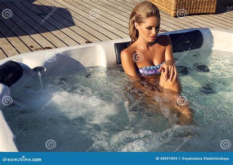 Sexy Vrouw Met Blond Haar In Bikini Het Ontspannen In Openluchtdraaikolk Stock Foto Image Of