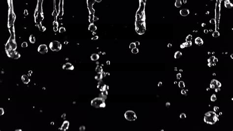 Super Slow Motion Shot Of Falling Water Droplets Isolated On Black