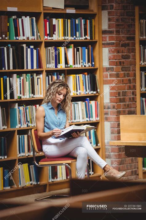 Woman Sitting And Reading Book In Library Books Railing Stock