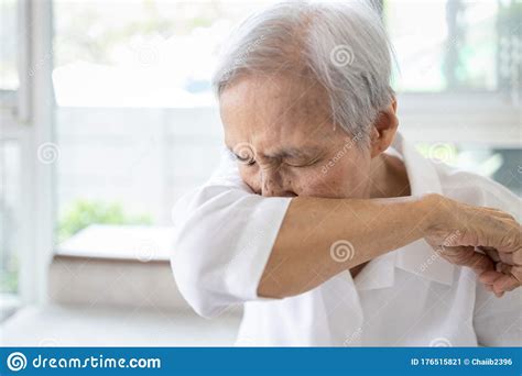 Asian Elderly People Sneezingcoughing Into Her Sleeve Or Elbow To