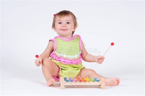 Girl With Excitement Playing On A Xylophone Isolated On White Stock