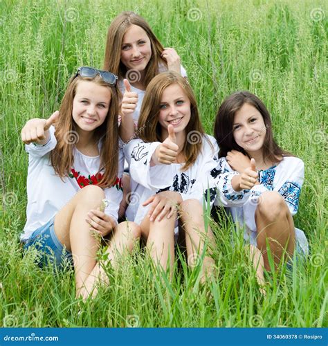 Four Happy Young Women Friends Smiling And Showing Thumbs Up In Green
