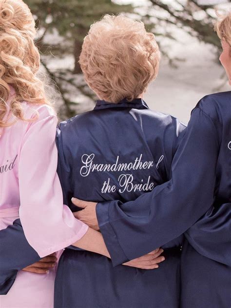 three bridesmaids in matching robes with the words grandmother and the bride written on them