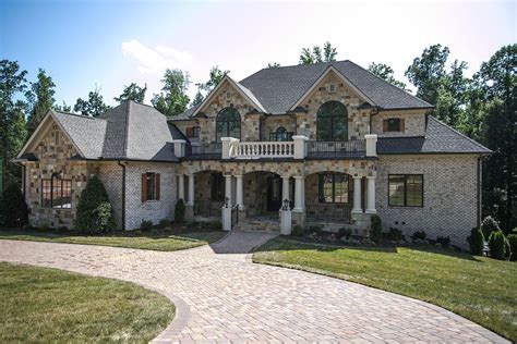 A Large Brick House With Lots Of Windows And Stone Walkway Leading To
