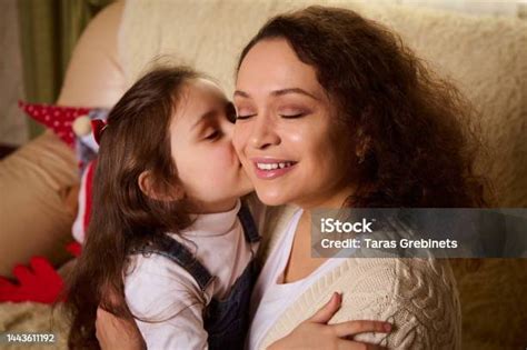 Delightful Young Woman A Loving Mother Experiences Happiness When Her Adorable Daughter Hugs And