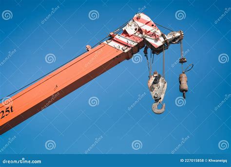 Boom Lifting Crane With Cable Hook Against Blue Sky Background