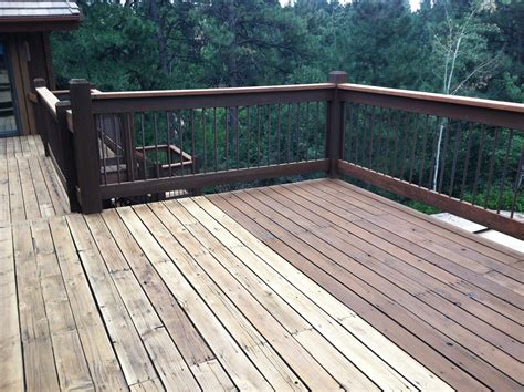 A Wooden Deck With Rocking Chairs And Trees In The Background