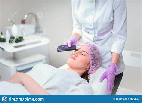 Hands Of Cosmetologist Making Ultrasound Facial Cleaning With Special