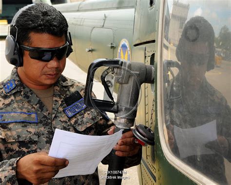 A Honduran Crew Chief Consults His Aircraft Fueling Checklist
