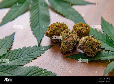 Detail Of Dried Cannabis Nugs And Leaves Over Wood Background Medical