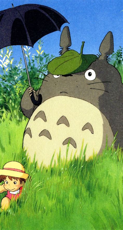 A Person Holding An Umbrella In The Grass With A Totoro Standing Next To It