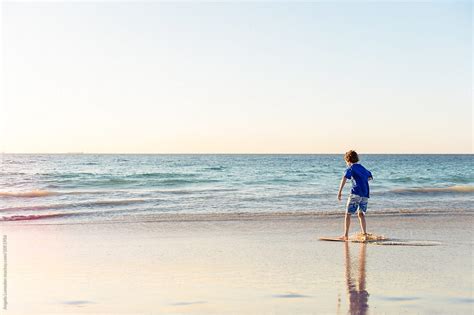 Boy Riding A Skim Board At The Beach At Sunset By Stocksy Contributor