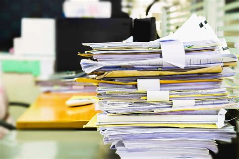Pile Of Unfinished Documents On Office Desk Stack Of Business Paper