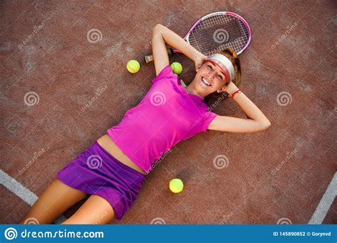 Tired But Smiling Young Female Tennis Player In Pink Uniform Lies On