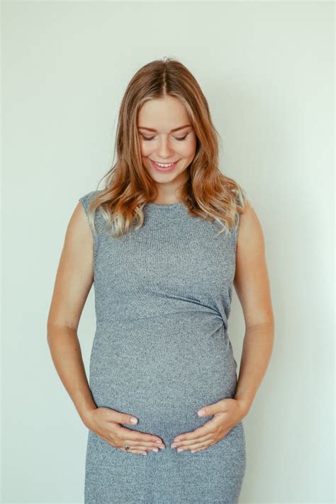 Caucasian Blonde Pregnant Woman In Grey Dress Touching Her Belly Stock Image Image Of Innocent
