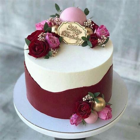 A Three Layer Cake Decorated With Flowers And An Egg