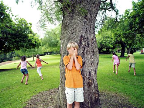 Boy 7 9 With Hands Covering Eyes Playing Hide And Seek In Park
