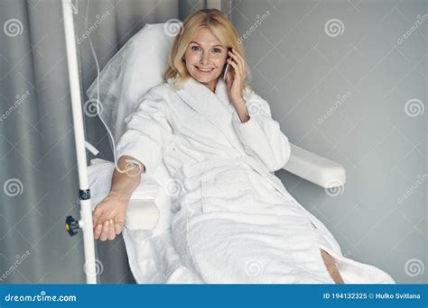 Excited Mature Woman Having Intravenous Therapy In Clinic Room Stock