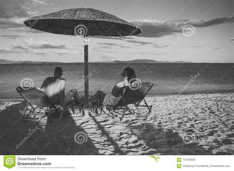 couple in love at sea resort sits on loungers under umbrella on sand beach couple on vacation
