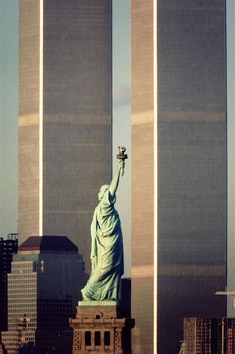 The Statue Of Liberty Flanked By The Twin Towers Of The