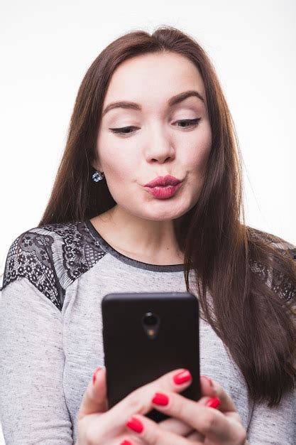 휴대 전화로 사진을 찍는 동안 입술을 Puckering 여자 무료 사진