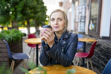 Portrait Of Serious Woman Drinking Coffee In Sidewalk Cafe Photo12
