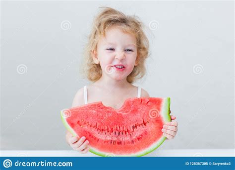 Cute Little Baby Girl Eating Watermelon Slice On Light