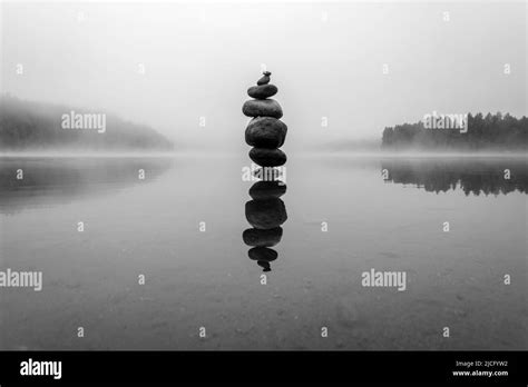 A Pile Of Rocks In Water With Reflection Stock Photo Alamy