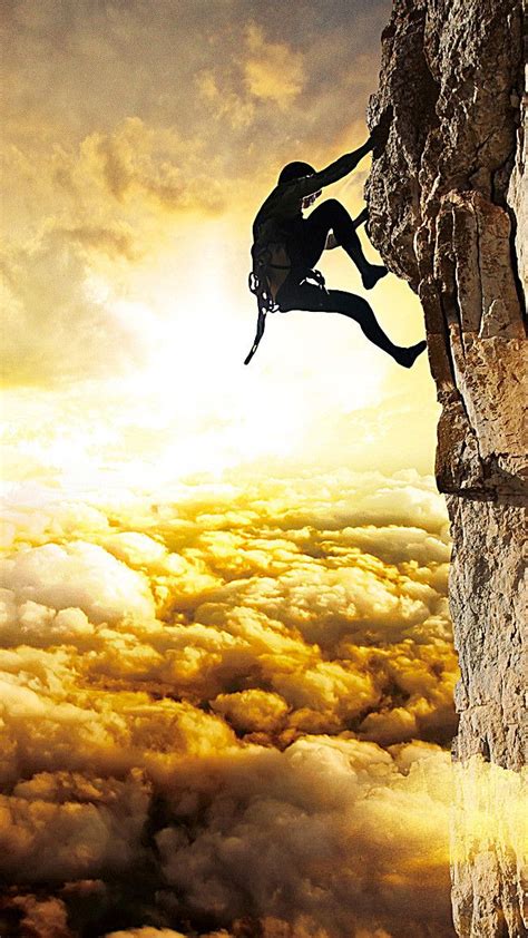 A Man Climbing Up The Side Of A Cliff