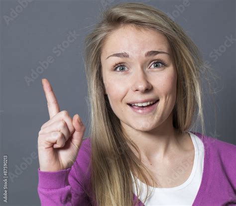 Thrilled 20s Blonde Girl Raising Her Index Finger For Answering