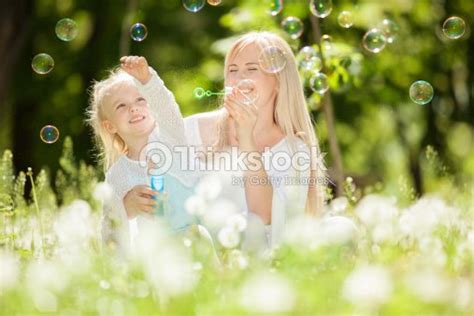 Feliz Madre E Hija En El Parque Soplando Burbujas Foto De Stock