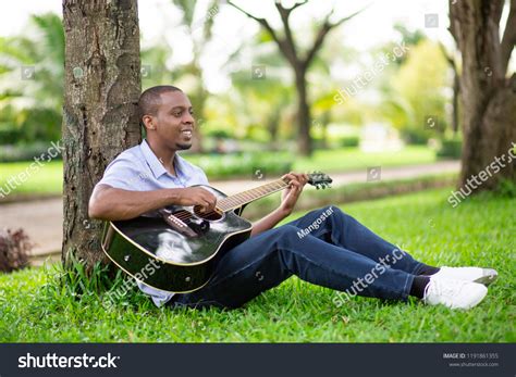 Smiling Black Man Playing Guitar Sitting Stock Photo 1191861355