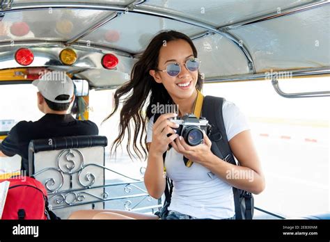 Happy Smiling Female Asian Tourist Backpacker Holding Camera While