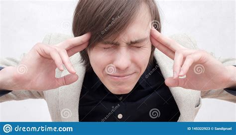 Tightly Closing His Eyes A Man Struggling With A Headache Stock Image