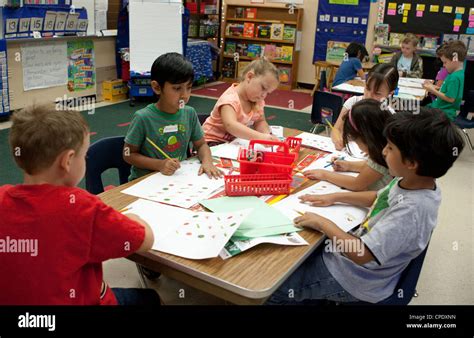 Multi Ethnic Group Of Kindergarten Students Work At A Large Table In