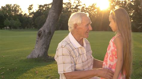 Grandfather With Teenage Granddaughter Her Head On His Shoulder Both