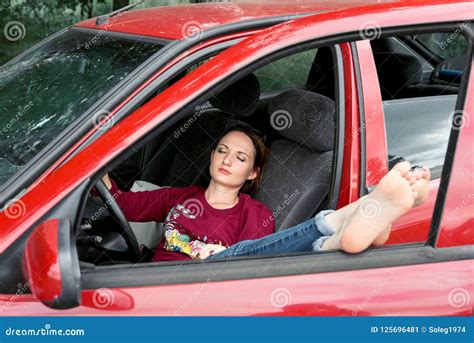 Young Woman Driver Resting In A Red Car Put Her Feet On The Car Window