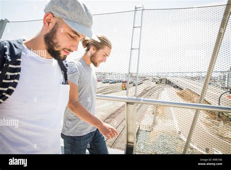 Two Young Men Walking Along A Footbridge City Life Stock Photo Alamy